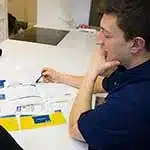 Person with hand under his chin looking at paperwork